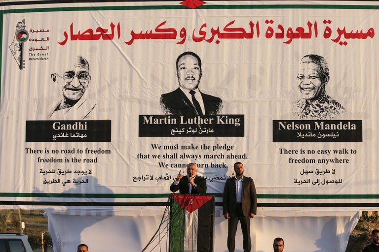 كان مشهداً مذهلاً حينما ظهر هنية أمام صورة لعمالقة المقاومة السلمية.. نيويورك تايمز: حماس نجحت في دمج نفسها بـ”دهاء” في المقاومة الشعبية