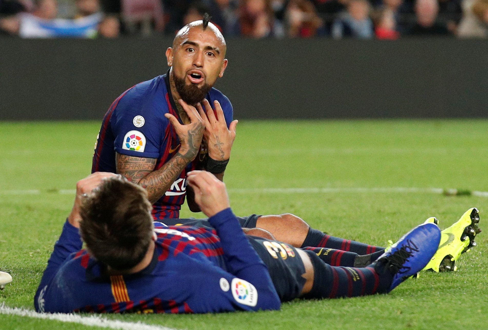لاعب برشلونة التشيلي ارتورو فيدال وزميله جيرارد بيكيه في لقاء برشلونة وريال بيتيتس ضمن منافسات الدوري الإسباني (رويترز)