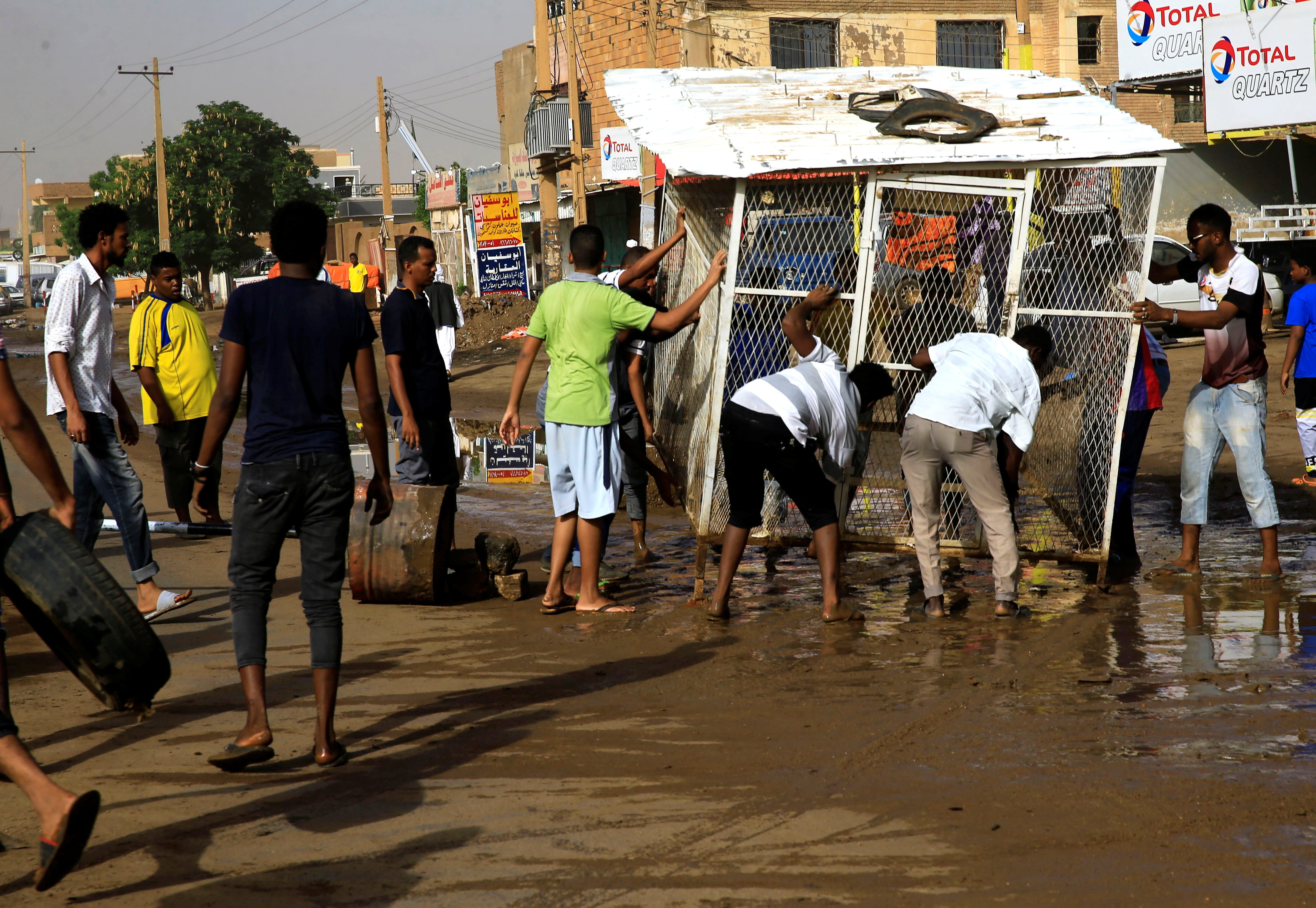 متظاهرون سودانيون يحاولون غلق الشوارع أمام الجيش/ رويترز
