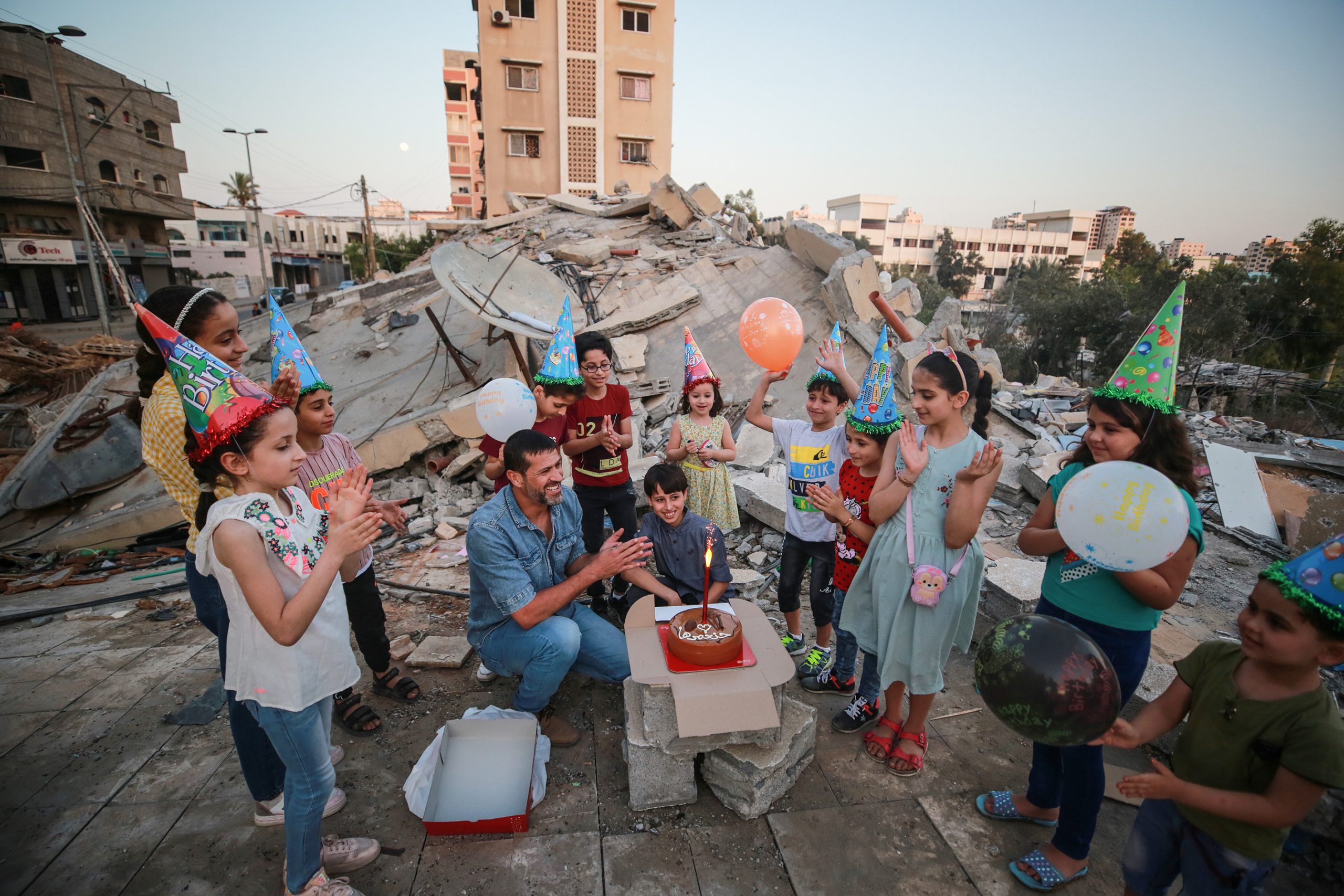 عائلة فلسطينية تحتفل بعيد ميلاد نجلها فوق ركام منزلها بغزة.. وحلاق يمارس مهنته على أنقاض بيته (صور)