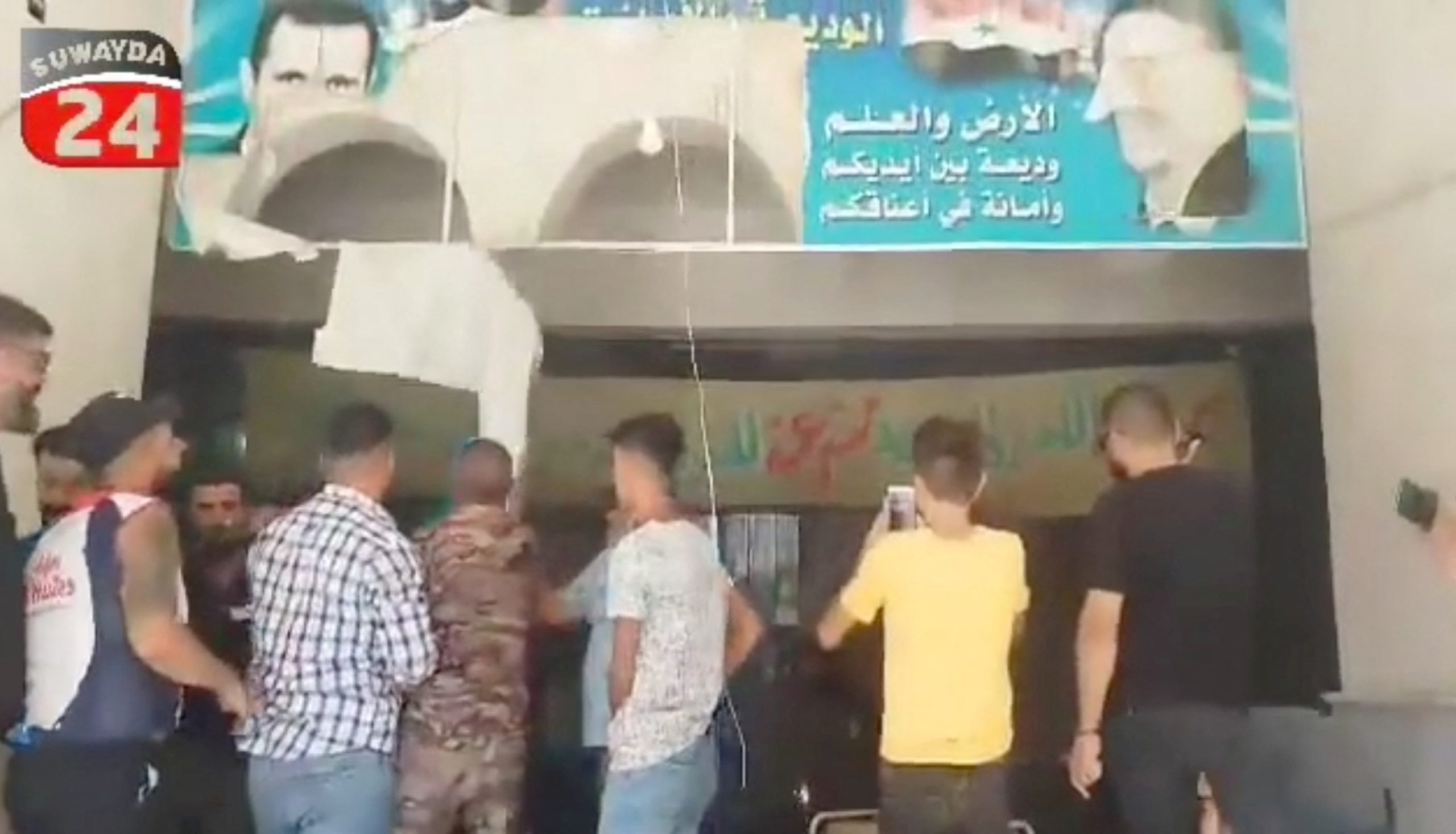 فيديو لمتظاهرين يزيلون صورة كبيرة لحافظ الأسد في السويداء.. ودعوات للاحتجاج على نطاق واسع